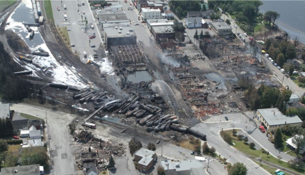 The downtown area of Lac-Megantic, Quebec after the oil train derailment and explosion of 2013. Photo Credit: Transportation Safety Board of Canada[/caption]